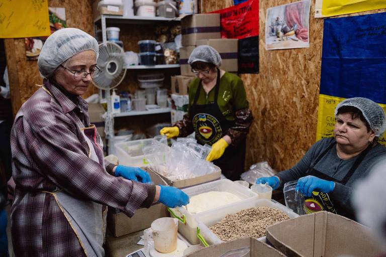 Valentina empacota alimentos desidratados ao lado de outras voluntárias na sede do projeto 'Borsht for Victory' em Kiev