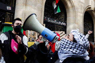 Masked youths take part in the occupation of a building of the Sciences Po University in support of Palestinians in Gaza, in Paris