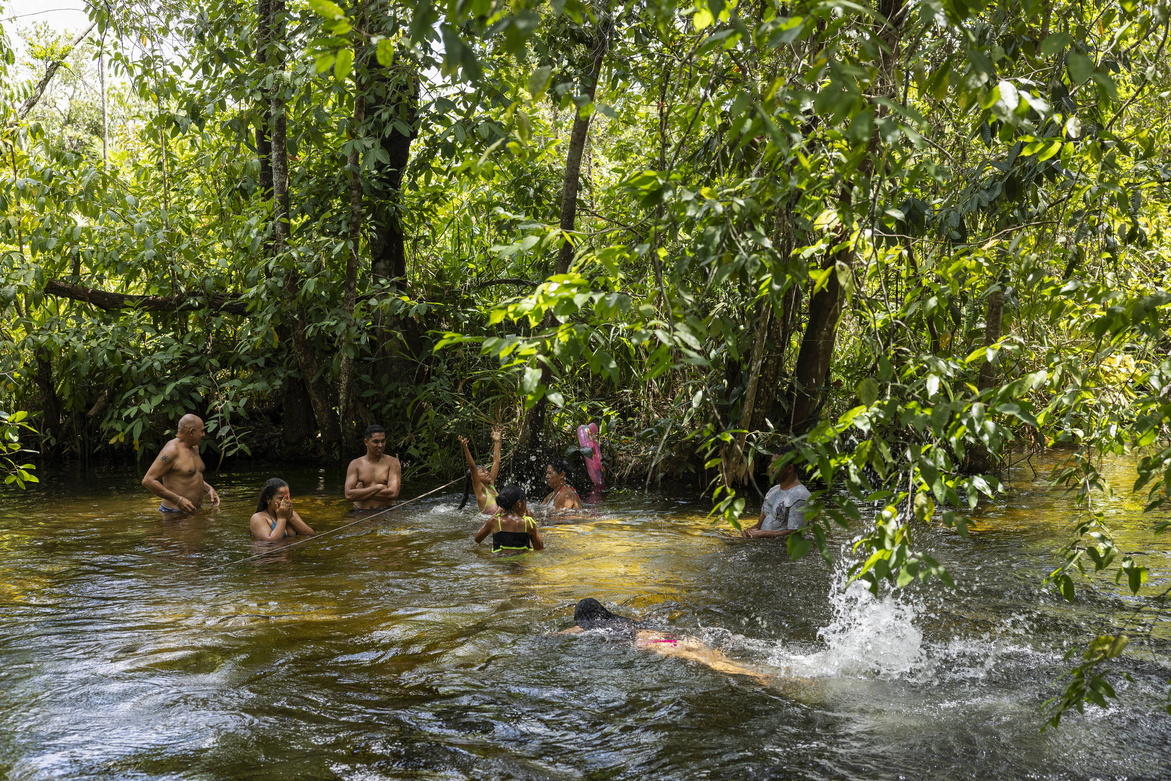 Moradores tomam banho de rio em dia de calor