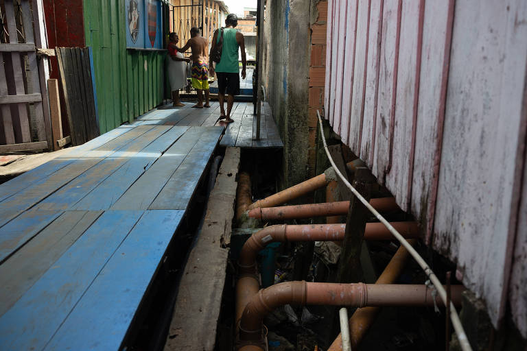 Tubulação suspensa coleta esgoto de palafitas em Manaus
