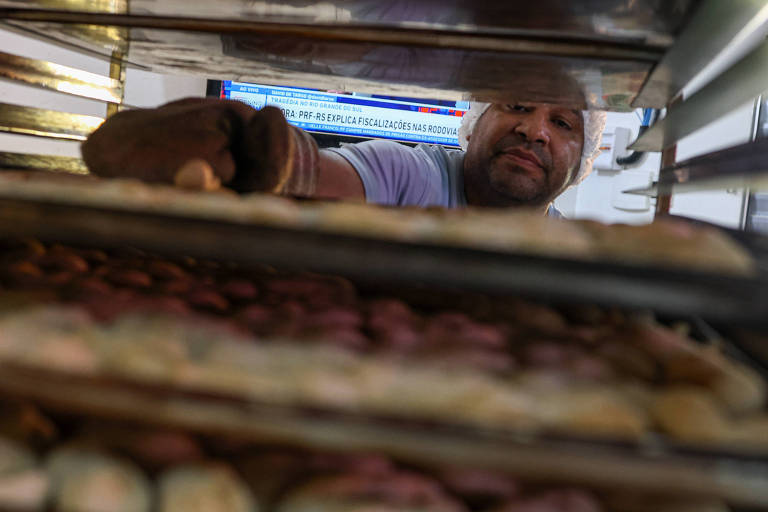Ronaldo Silva tira fornada de biscoitos de polvilho produzida na favela Haiti