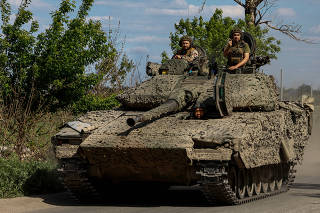 Ukrainian servicemen ride along a road in a CV90 infantry fighting vehicle in Donetsk region