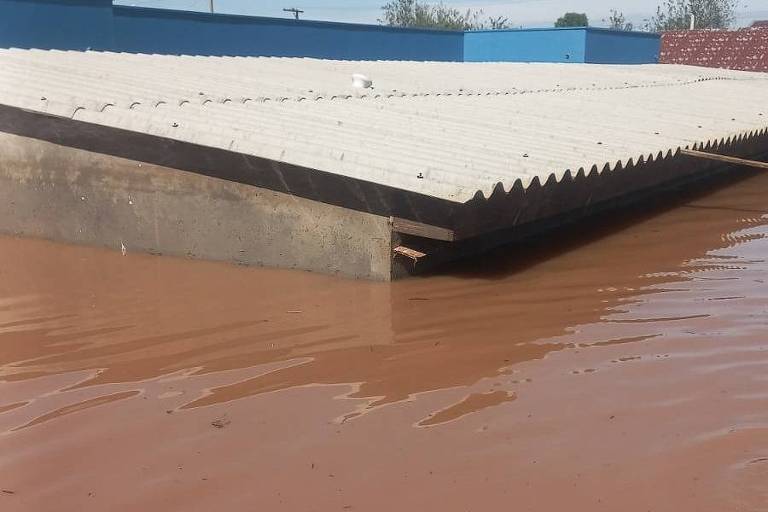 Água marrom cobrindo construção até quase o telhado