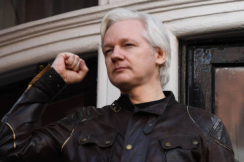 (FILES) Wikileaks founder Julian Assange raises his fist prior to addressing the media on the balcony of the Embassy of Ecuador in London on May 19, 2017. WikiLeaks founder Julian Assange on May 20, 2024, won his UK court bid to appeal against a previous ruling approving his extradition to the United States to face trial on espionage charges. Two High Court judges granted Assange permission to appeal, having previously asked the US to provide 