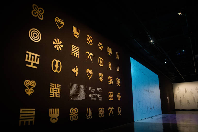 Parede da exposição 'Línguas africanas que fazem o Brasil' adornadas por adinkras, símbolos utilizados como sistema de escrita pelo povo ashanti