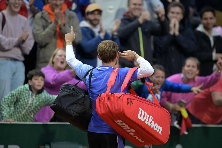 Tenista belga David Goffin comemora com a torcida após vitória contra o francês Giovanni Mpetshi Perricard, em Roland Garros 