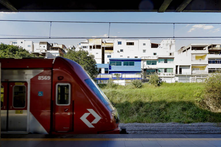 Imagem mostra trem com casas ao fundo