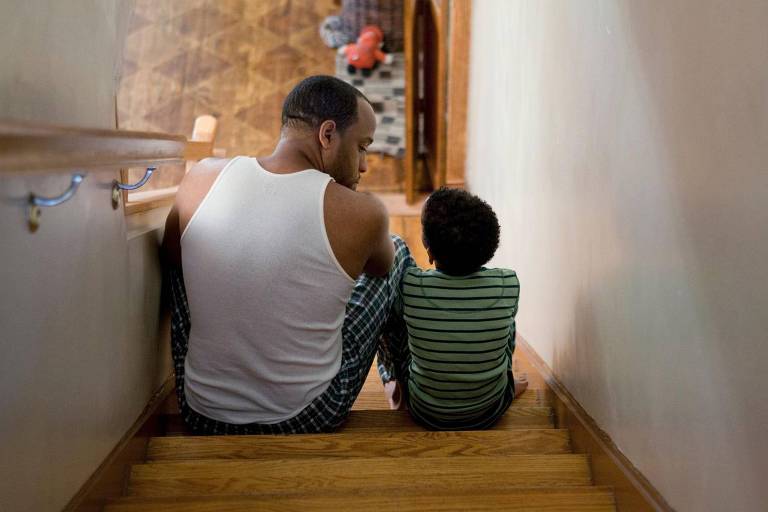Pai e filho sentados na escada
