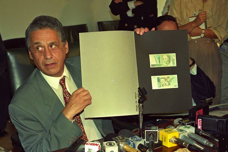 O então ministro da Fazenda Fernando Henrique Cardoso apresentando em março de 1994 as cédulas de real. Haviam notas de R$ 1,00, R$5,00, R$10,00, R$50,00 e R$100,00