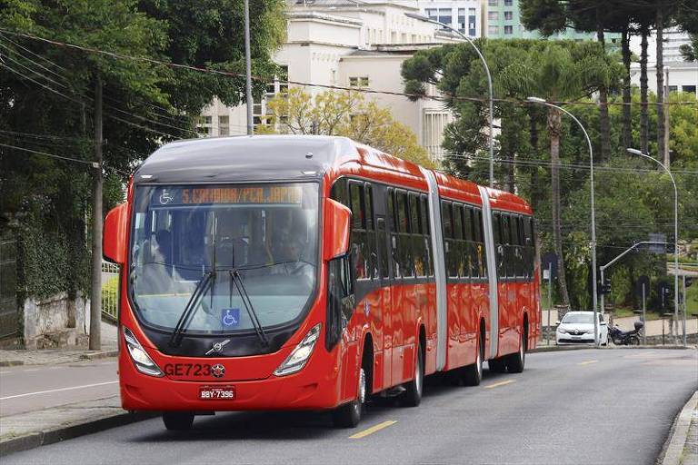 ônibus biarticulado vermelho em rua de Curitiba
