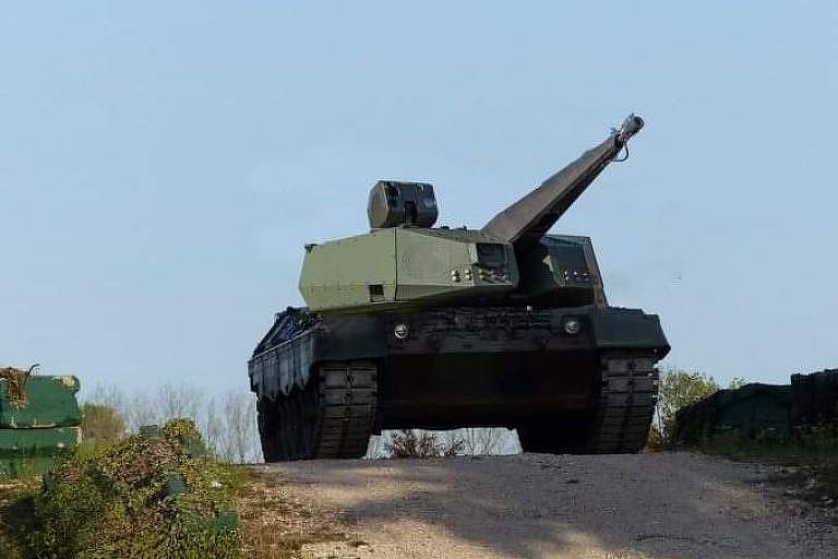 Imagem de computador simula um tanque verde com o canhão apontado para cima em uma estrada de terra