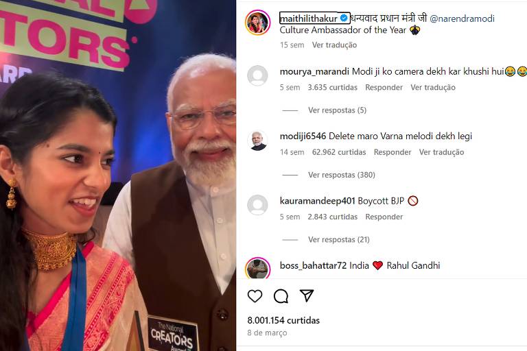 A imagem mostra uma selfie de duas pessoas sorrindo. A pessoa à esquerda é uma mulher jovem vestindo um saree rosa com detalhes dourados e uma blusa azul. A pessoa à direita é um homem mais velho com barba branca, vestindo um colete marrom sobre uma camisa branca. Ao fundo, há um banner colorido com as palavras 'WORLD RECORDS' parcialmente visíveis. Na parte superior da imagem, há uma seção de comentários de uma rede social, com vários usuários comentando sobre a foto.