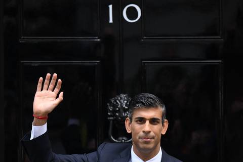 (FILES) Britain's newly appointed Prime Minister Rishi Sunak waves as he poses outside to door to 10 Downing Street in central London, on October 25, 2022, after delivering his first speech as prime minister. Rishi Sunak is seeking his own public mandate at next month's general election, on July 4, 2024, having been installed as Conservative leader and UK prime minister by his own colleagues in parliament. The 44-year-old former financier was tasked with stabilising the UK economy, and his own notoriously fractious party, when he succeeded Liz Truss in October 2022 after her 49-day premiership imploded. (Photo by Daniel LEAL / AFP)