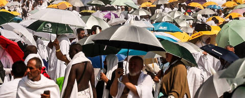 (FILES) Muslim pilgrims use umbrellas to shade themselves from the sun as they arrive at the base of Mount Arafat, also known as Jabal al-Rahma or Mount of Mercy, during the annual hajj pilgrimage on June 15, 2024. Saudi Arabia said on June 23 that more than 1,300 faithful died during the hajj pilgrimage which took place during intense heat, and that most of the deceased did not have official permits. (Photo by Fadel SENNA / AFP) ORG XMIT: 378