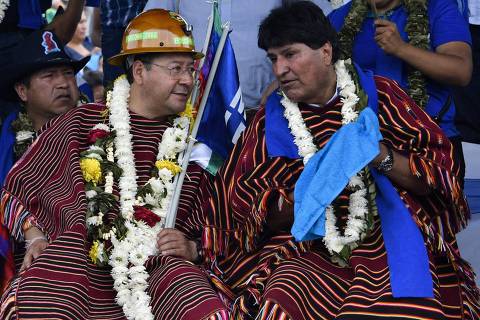 (FILES) Bolivia's president Luis Arce (L) and ex-president (20062019) Evo Morales, with garlands of flowers and coca leaves, talk during a political gathering to mark the 28th anniversary of the ruling Movement for Socialism (MAS) party, in Ivirgarzama, in the coca-growing rural province of Chapare, Cochabamba Department, in central Bolivia, on March 26, 2023. Former leftist president Evo Morales announced on September 24, 2023, that he will run for the Bolivian presidency in 2025, amid a growing political confrontation with the government of his political heir, Luis Arce. (Photo by Aizar RALDES / AFP) ORG XMIT: 016931