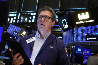 FILE PHOTO: Traders work on the floor of the NYSE in New York