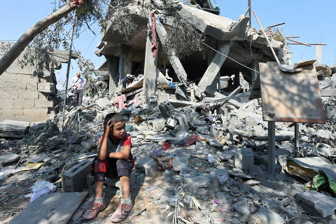 A child sits amid the rubble as Palestinians inspect a house destroyed in an Israeli strike, amid the Israel-Hamas conflict, in Nusairat refuge camp, in the central Gaza Strip, July 9, 2024. REUTERS/Ramadan Abed     TPX IMAGES OF THE DAY ORG XMIT: LIVE