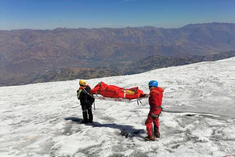 Undated handout picture released by Peruvian National Police on July 8, 2024, showing police officers evcacuating the body of US mountain climber William Stampfl, who was reported missing in June 2002, in the Ancash region, 400 km north of Lima. The body of an US mountain climber who disappeared 22 years ago while climbing a 6,700-metre-high mountain in Peru was found mummified and with his clothes in good condition, police said on July 8, 2024. (Photo by Handout / Peruvian National Police / AFP) / RESTRICTED TO EDITORIAL USE - MANDATORY CREDIT 