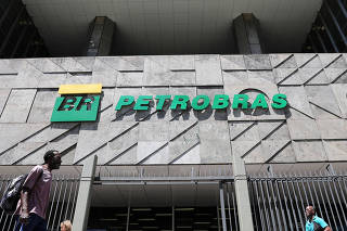 FILE PHOTO: People walk in front of the headquarters of Petroleo Brasileiro S.A. (Petrobas) in Rio de Janeiro