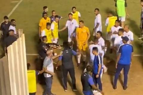 Policial segura arma durante confusão na lateral do estádio Jonas Duarte