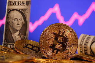 FILE PHOTO: A representation of virtual currency Bitcoin and U.S. One Dollar banknote are seen in front of a stock graph in this illustration