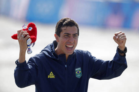 Paris 2024 Olympics - Athletics - Men's 20km Race Walk - Trocadero, Paris, France - August 01, 2024. Silver medallist Caio Bonfim of Brazil celebrates on the podium while holding Olympics mascot the Phryges during the venue ceremony. REUTERS/Amanda Perobelli