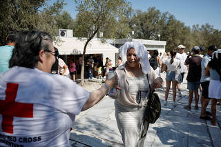 Red Cross volunteers distribute water and leaflets near the Acropolis amid heatwave in Athens