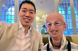 Dr. David Liu, left, with Sammy Basso, 27, currently one of the oldest living progeria patients, at a conference in Sweden in 2023.  (David Liu via The New York Times)