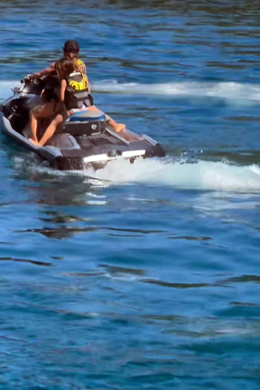 A imagem mostra duas pessoas em um jet ski, navegando em águas azuis