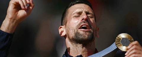 Gold medallist, Serbia's Novak Djokovic poses with his medal on the podium at the presentation ceremony for the men's singles tennis event on Court Philippe-Chatrier at the Roland-Garros Stadium during the Paris 2024 Olympic Games, in Paris on August 4, 2024. (Photo by CARL DE SOUZA / AFP)