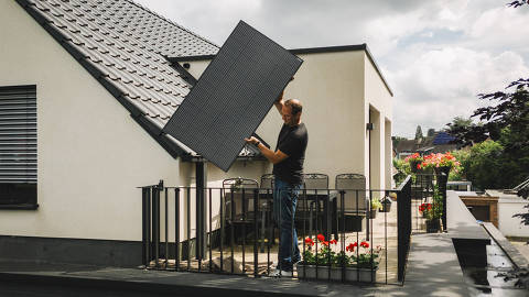 Heiko Billen installs a solar panel at his house in Düsseldorf, Germany, on July 10, 2024. People across Germany are installing lightweight solar panels, without the need for an electrician or heavy tools. (Patrick Junker/The New York Times) ORG XMIT: XNYTI DIREITOS RESERVADOS. NÃO PUBLICAR SEM AUTORIZAÇÃO DO DETENTOR DOS DIREITOS AUTORAIS E DE IMAGEM