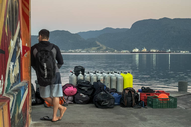 Assim que os primeiros raios de sol iluminaram o céu, pelo menos duas dezenas de gente sonolenta, cilindros de ar comprimido e bolsas com equipamentos já esperavam a chegada do barco no porto do Perequê, em Ilhabela