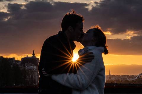 TOPSHOT - A couple kiss at sunset on the Pont des Arts bridge over the river Seine, in Paris on April 23, 2024. (Photo by Martin BUREAU / AFP)