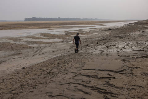 TEFE, AM. 18/09/2024. Ralison dos Anjos caminha  pelo leito seco de um braço do rio Solimões proximo a comunidade indígena Porto Praia, município de Tefé. ( Foto: Lalo de Almeida/ Folhapress ) AMBIENTE *** EXCLUSIVO FOLHA***