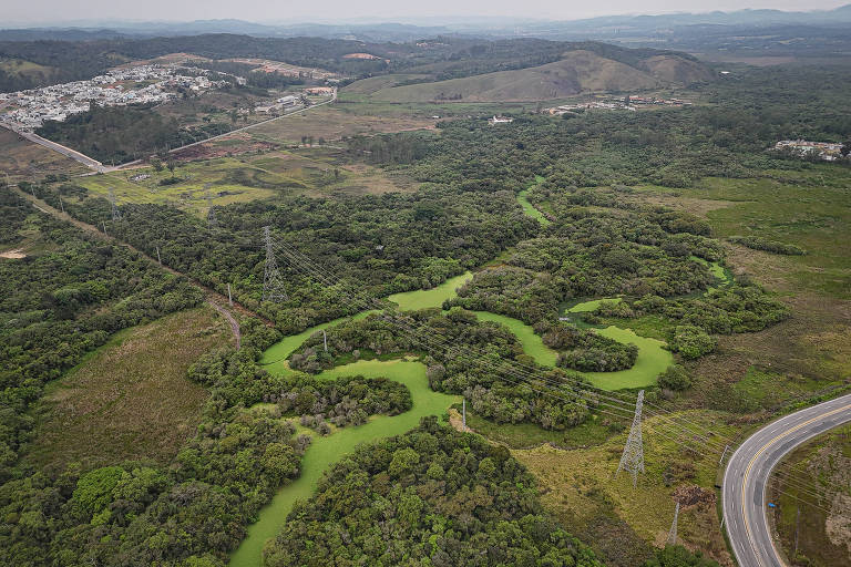 Rio visto de cima, com drone; há trechos com a água verde, poluída