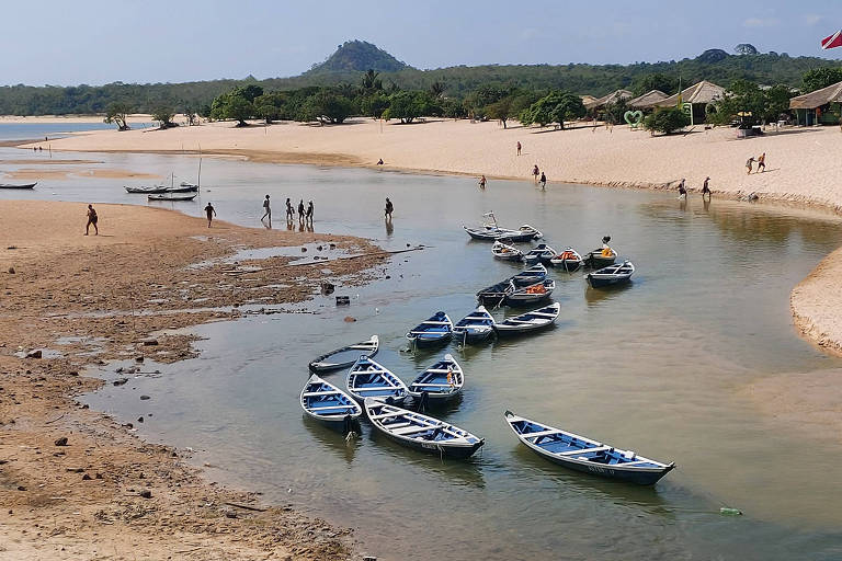 Turista anda a pé trecho de rio em Alter do Chão, que sofre com seca severa pelo 2º ano seguido