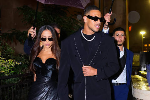 Anitta deixa desfile da Balmain com Vinicius Souza

Manuela Scarpa - 25.set.2024/BrazilNews *** Local Caption *** Um casal caminha sob a chuva, ambos usando óculos escuros. A mulher veste um vestido longo preto com um corpete estruturado e uma saia drapeada, enquanto o homem usa um traje preto com detalhes brilhantes e uma corrente no pescoço. Eles estão de mãos dadas,