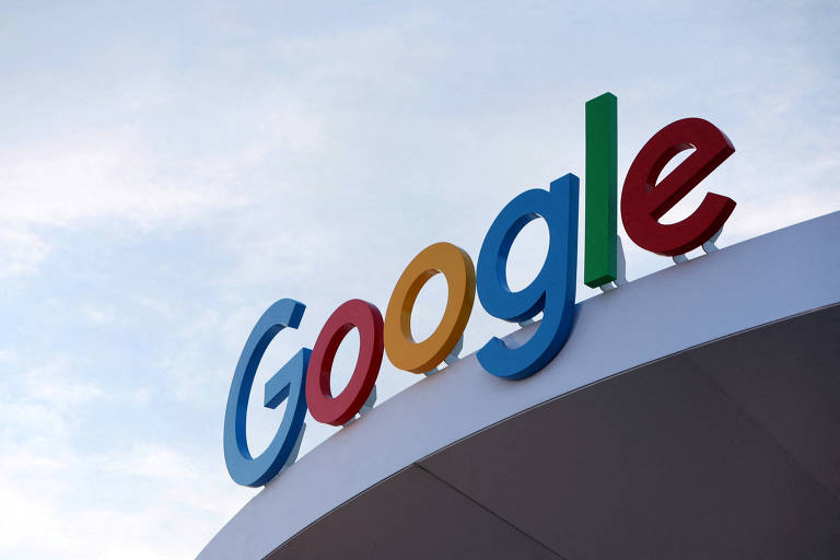 A imagem mostra o logotipo do Google, com as letras 'G', 'o', 'o', 'g' e 'l' em cores diferentes: azul, vermelho, amarelo, azul e verde, respectivamente. O logotipo está posicionado em uma estrutura curva, com um céu claro ao fundo.
