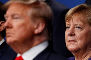 FILE PHOTO: U.S. President Donald Trump and Germany's Chancellor Angela Merkel pose for the family photo during the annual NATO heads of government summit at the Grove Hotel in Watford