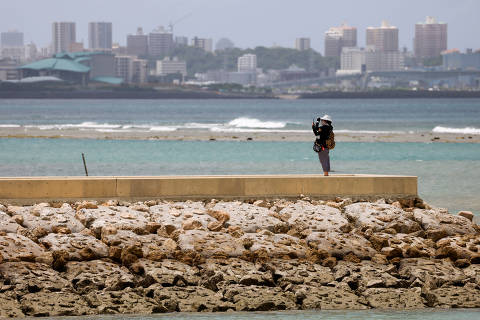 A visitor looks at the sea as Typhoon Haikui approaches the region, at Sunset Beach in Chatan, Okinawa prefecture, Japan September 1, 2023. REUTERS/Issei Kato ORG XMIT: GGGTOK602