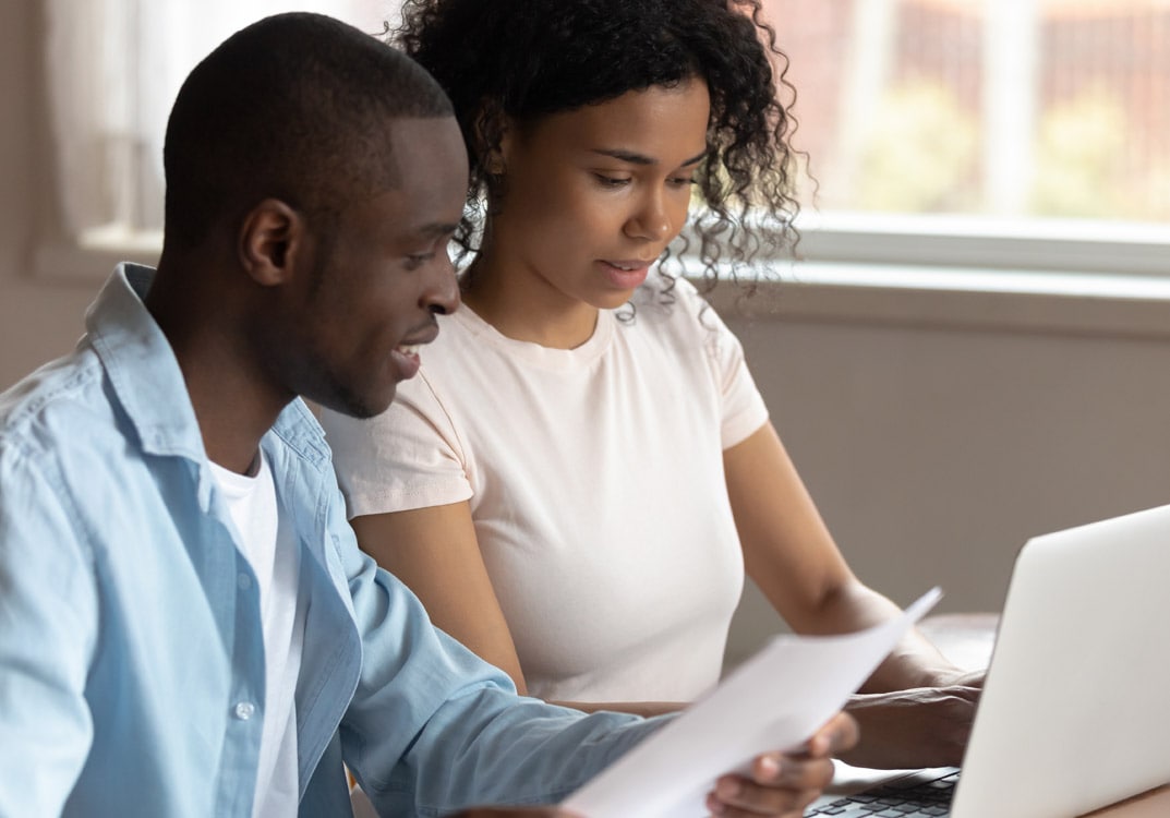 man and woman reviewing documents at computer