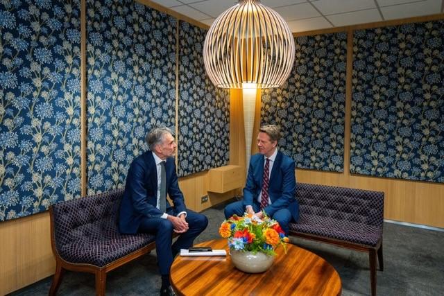 Links op een bank beoogd minister-president Dick Schoof, rechts op een andere bank Kamervoorzitter Martin Bosma. Voor hen een ronde salontafel met bloemen. 