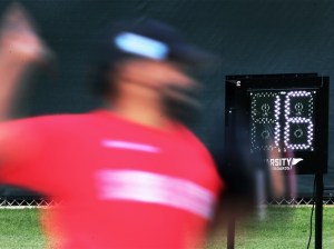 A blurry Boston Red Sox closer Kenley Jansen throws in front of a pitch clock