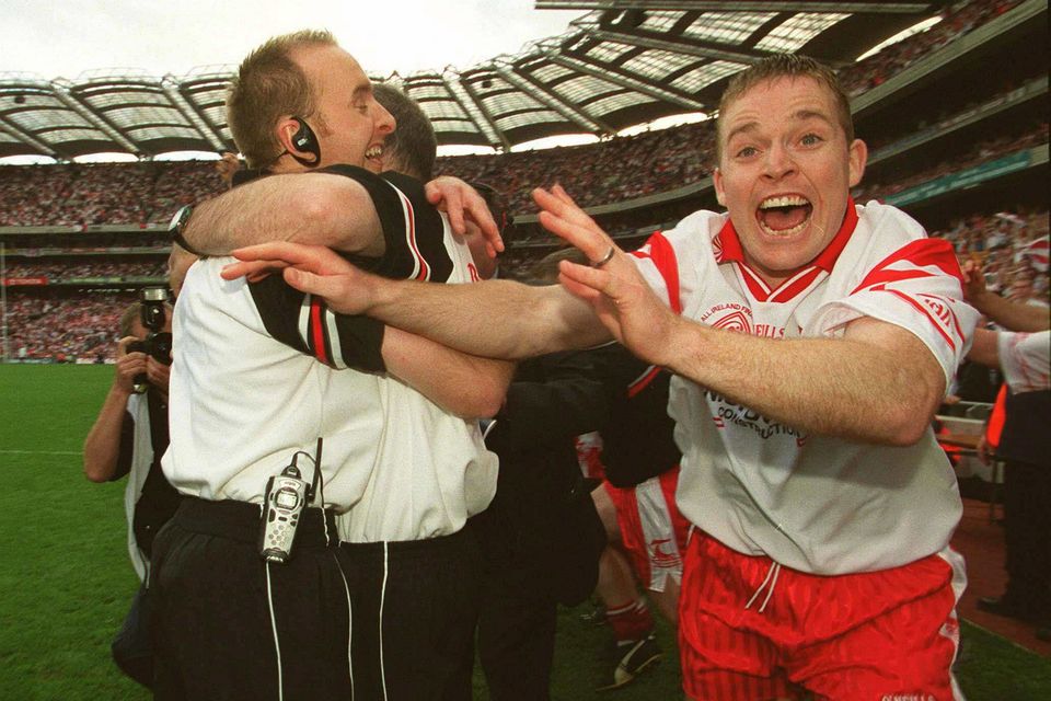 Tyrone manager Mickey Harte and Paddy Tally hug after the 2003 All-Ireland SFC win as Tyrone's Peter Loughran (right) celebrates.