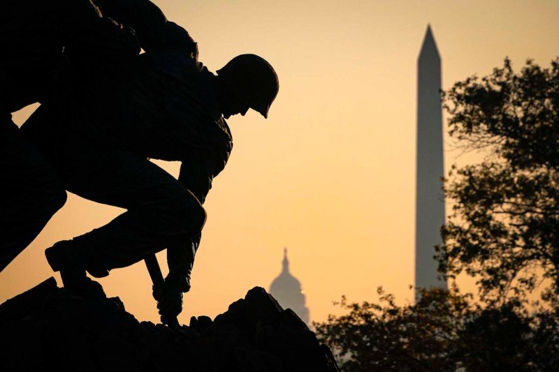 The U.S. Marine Corp’s Iwo Jima Memorial can be seen as sun begins to rise behind the U.S. Capitol and Washington Monument in Arlington, Virginia on Nov. 7, 2020.