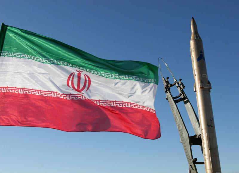 An Iranian flag flies next to a ground-to-ground Sejjil missile at an undisclosed location in Iran.