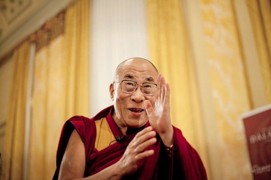 The Dalai Lama waves during a press conference