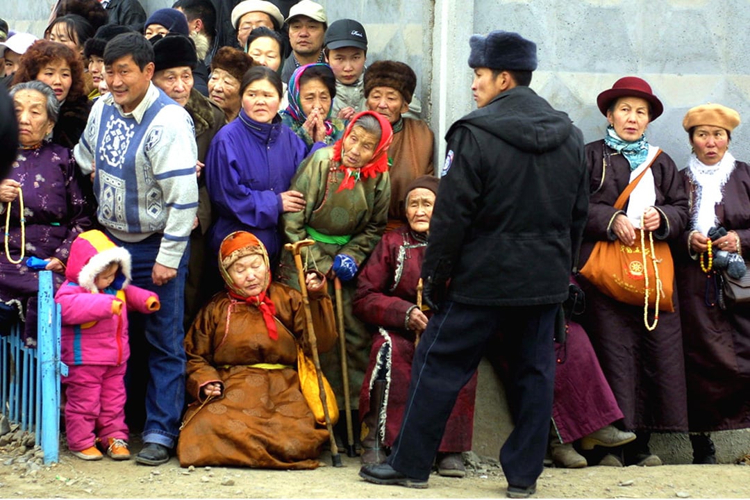 Mongolian Buddhists wait in line outside a Buddhist school.