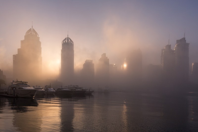 The foggy skyline of Dubai at sunrise.