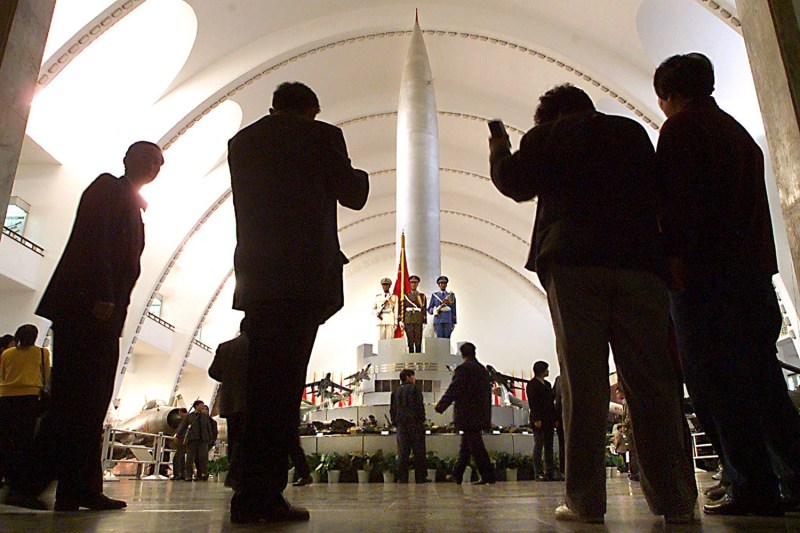 People pose for pictures in front of one of China's first nuclear missiles, the Dong Feng 1, as they visit the Military Museum of the Chinese People's Revolution.